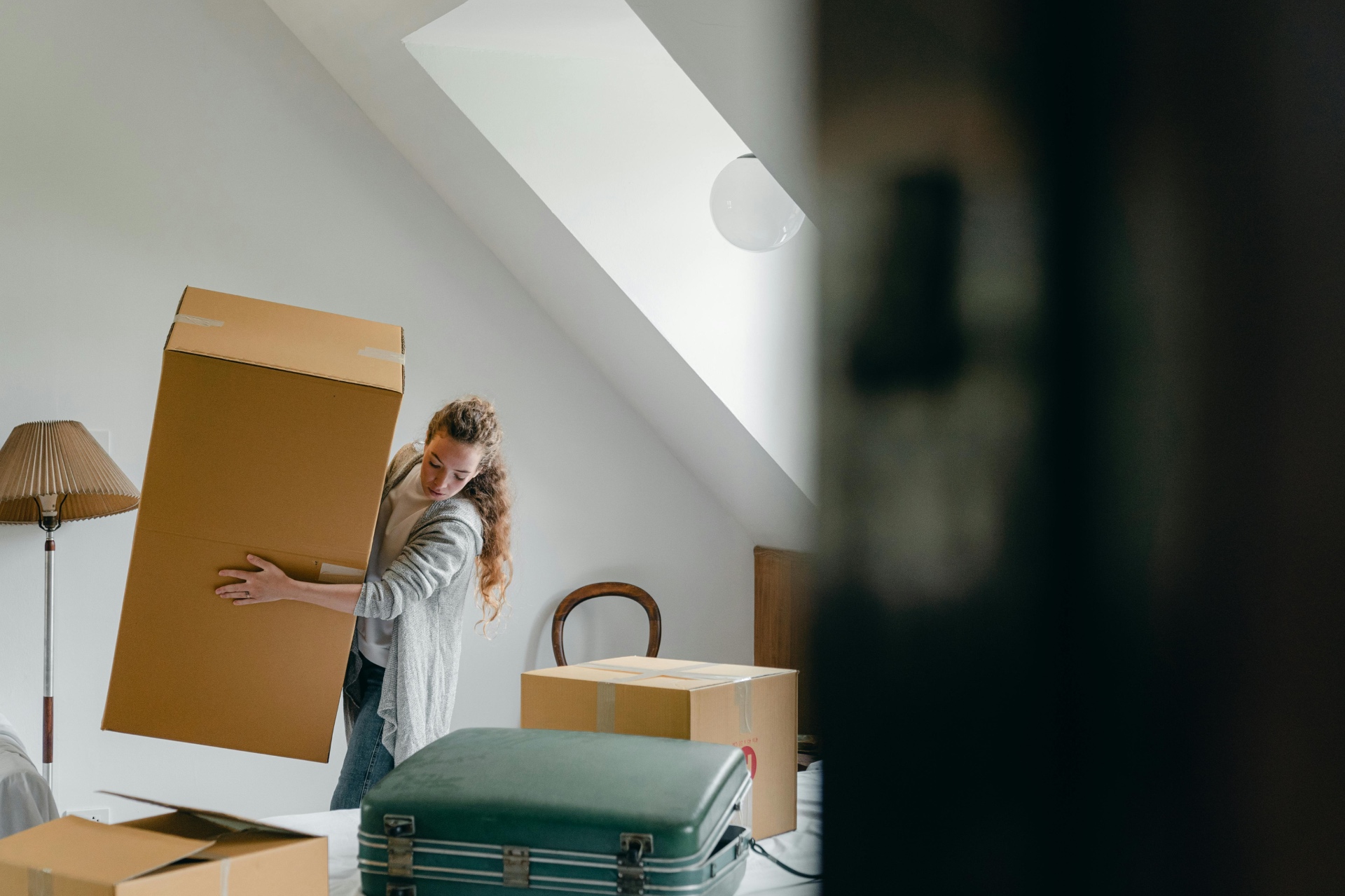 Woman moving home with boxes representing home protection and insurance during relocation