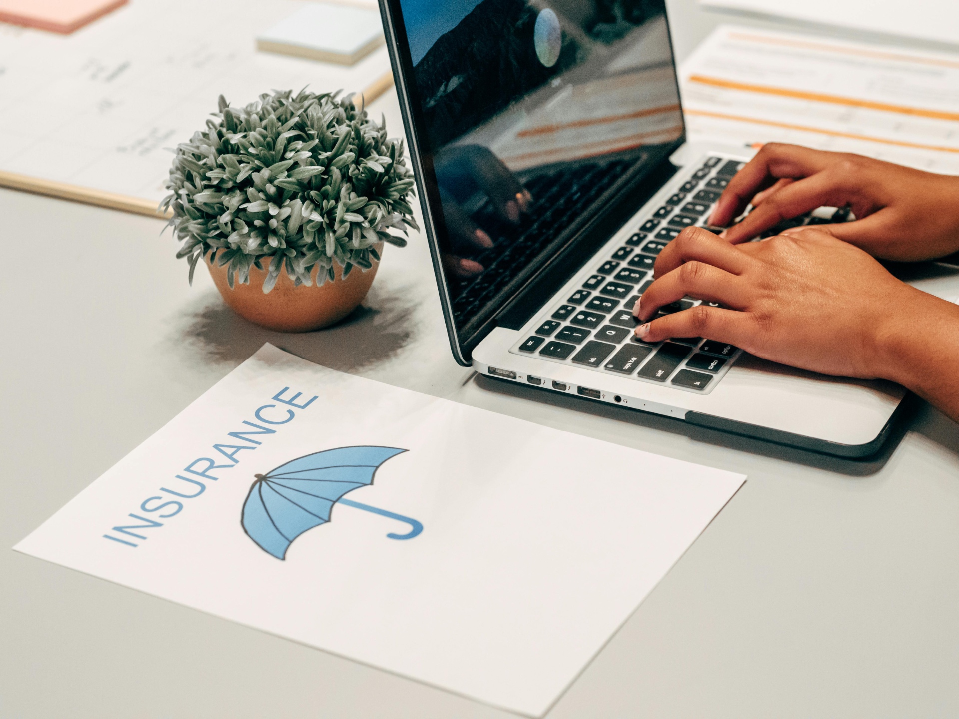 Insurance planning workspace with laptop and documents for coverage analysis